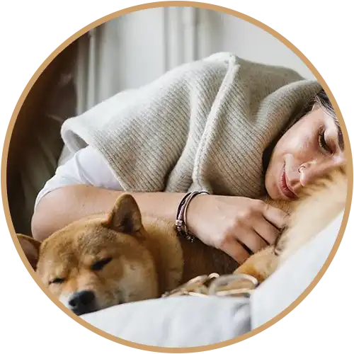 Woman and dog cuddling on a bed